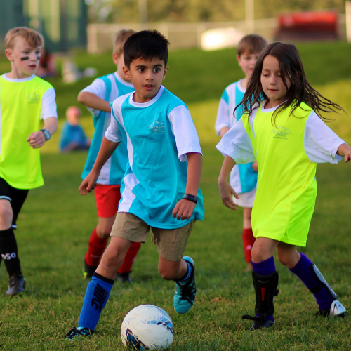 A child kicks a soccer ball during a soccer game.