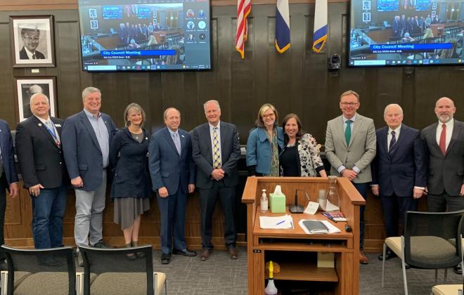 City council and may suthers standing in front of the dias