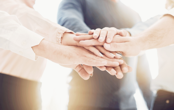 Hands gather in the middle for a team effort